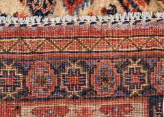 A close-up of a handwoven Afghan Chobi rug featuring intricate geometric patterns in warm tones.