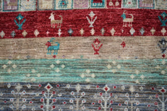 Handmade Afghan Chobi rug featuring horizontal bands of geometric patterns and animal motifs.