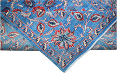 A handmade Afghan Chobi rug featuring a blue field with red and cream floral Suzani motifs.