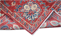 A handmade Afghan Chobi rug featuring a traditional red floral Suzani pattern on a wool pile.