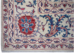 Handwoven Afghan Chobi rug featuring traditional Suzani floral motifs in red and blue on cream.