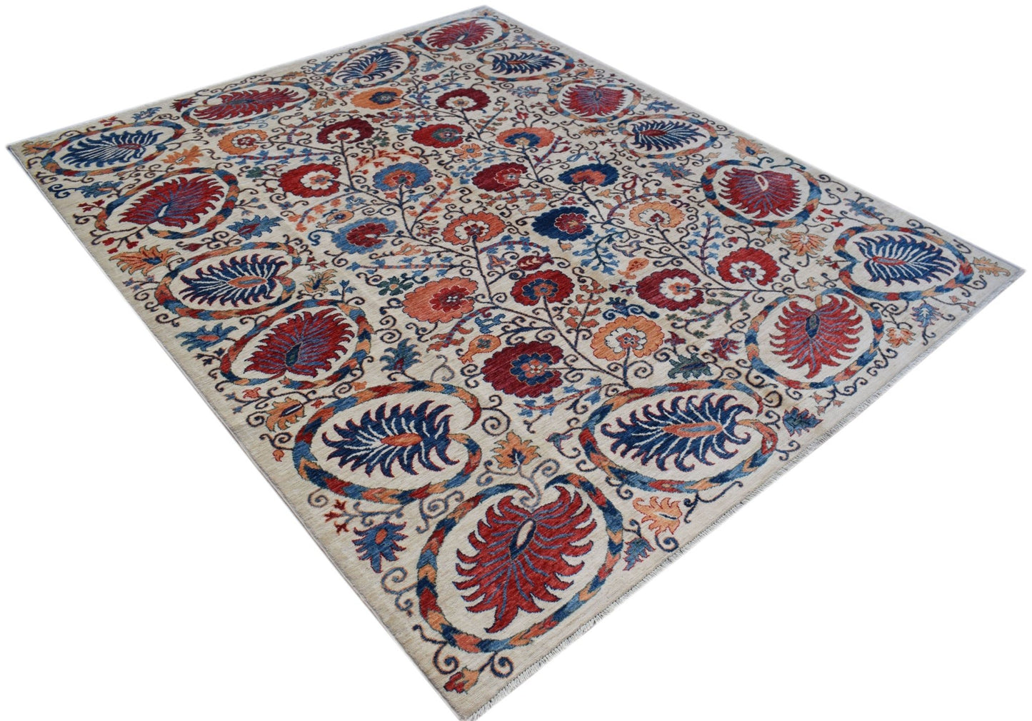 An Afghan Chobi rug featuring a traditional Suzani floral pattern in red, blue, and orange tones.