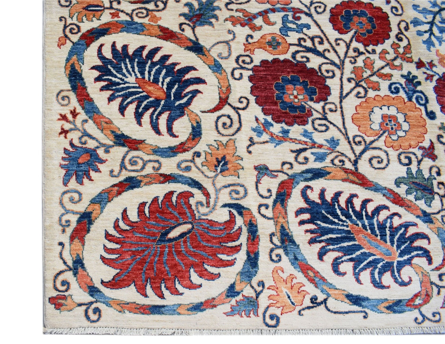 Handwoven Afghan Chobi rug featuring a traditional floral Suzani pattern in red, blue, and orange.