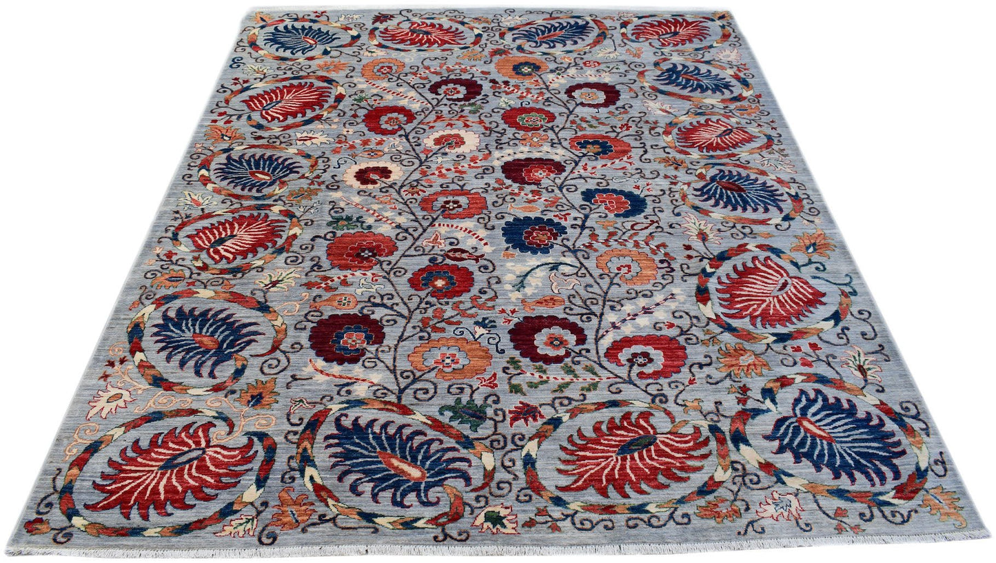 An Afghan Chobi rug featuring a floral Suzani pattern in red and blue on a light grey background.