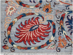 A handmade Afghan Chobi rug featuring a traditional Suzani floral pattern on a light blue background.
