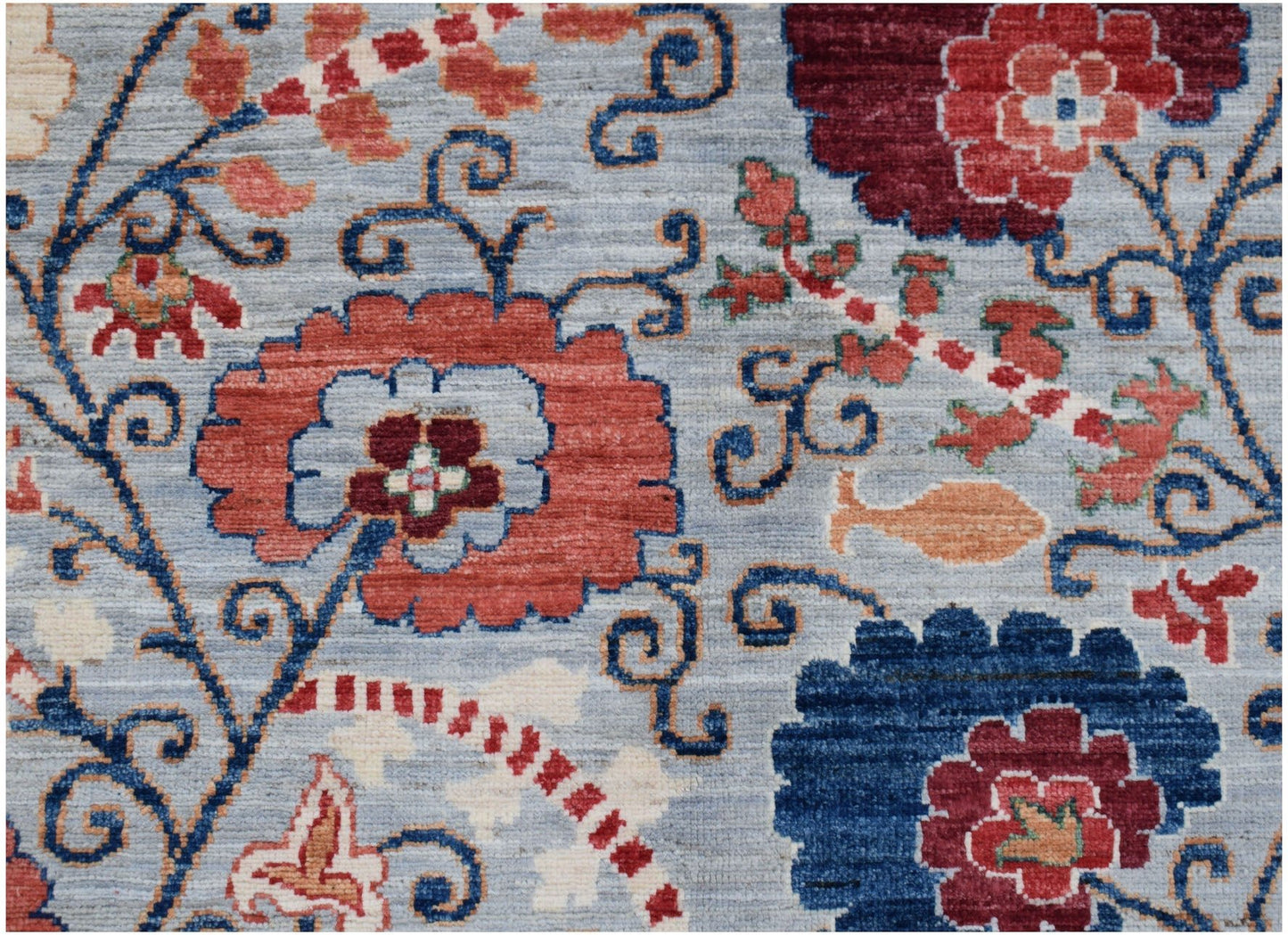 Handmade Afghan Chobi rug featuring a traditional floral Suzani pattern in red and blue tones.