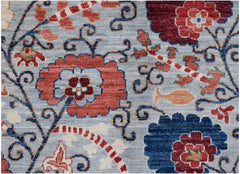 Handmade Afghan Chobi rug featuring a traditional floral Suzani pattern in red and blue tones.