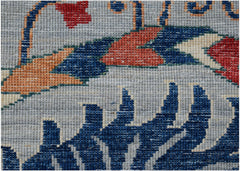 A close-up of an Afghan Chobi rug featuring intricate floral patterns in blue, red, and orange.