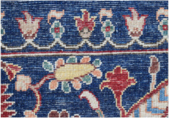 A close-up of a handmade Afghan Chobi rug featuring intricate floral patterns in a deep blue field.