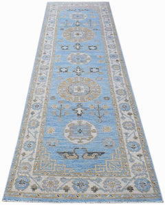 A handwoven Afghan Chobi runner rug featuring traditional geometric patterns in blue and beige.
