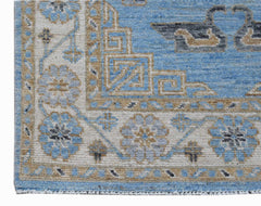 A corner view of a handwoven Afghan Chobi runner featuring blue and tan floral and geometric motifs.