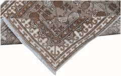 A handmade Afghan Chobi runner rug featuring a brown and cream geometric floral pattern.