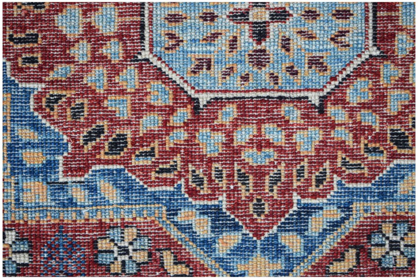 A close-up of a handwoven Afghan Chobi runner featuring a detailed red and blue Mamluk pattern.