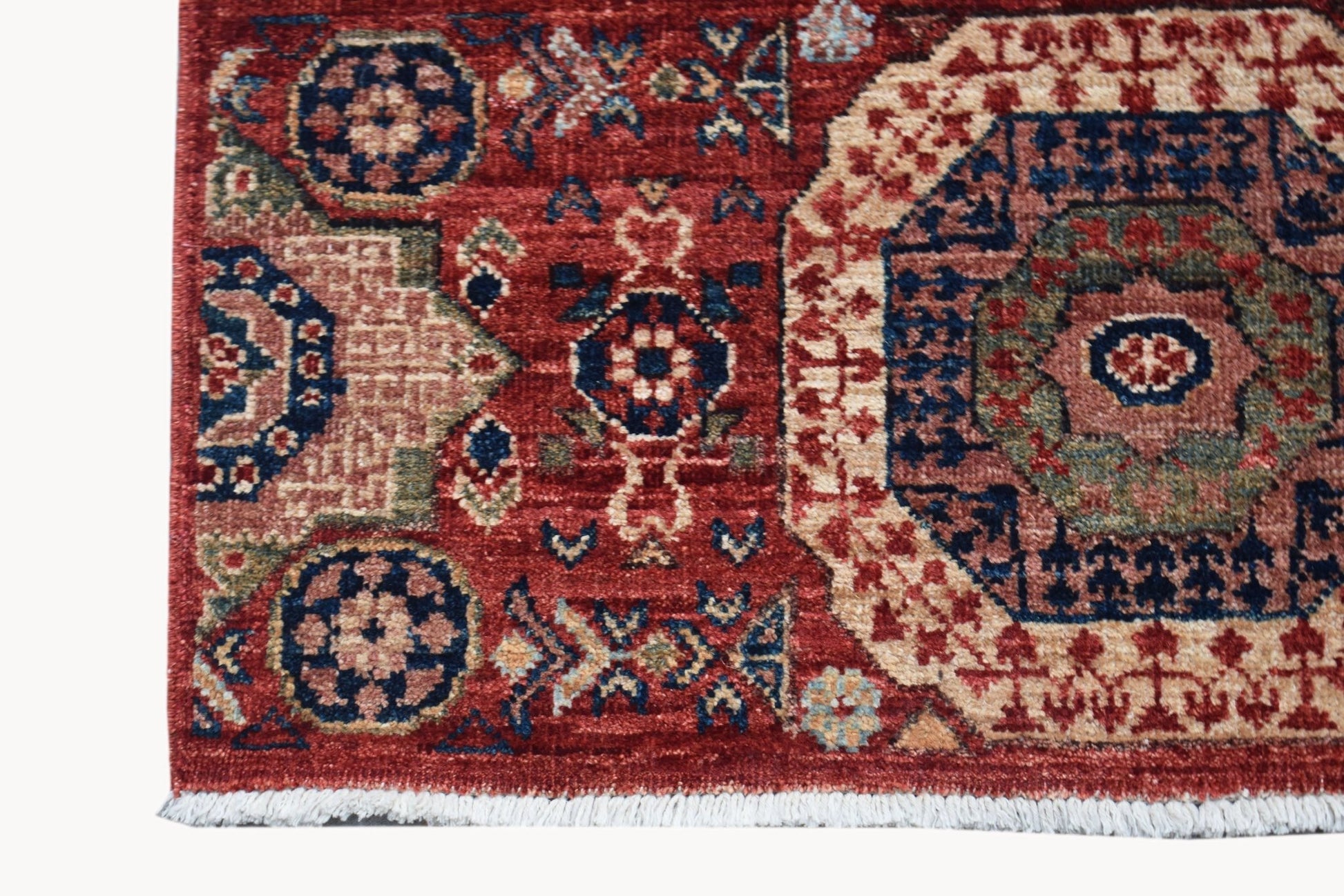 A handmade Afghan Chobi runner featuring a traditional red Mamluk medallion pattern.