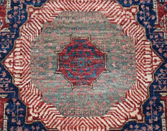 A handwoven Afghan Chobi runner featuring a detailed red and blue Mamluk medallion on a green field.