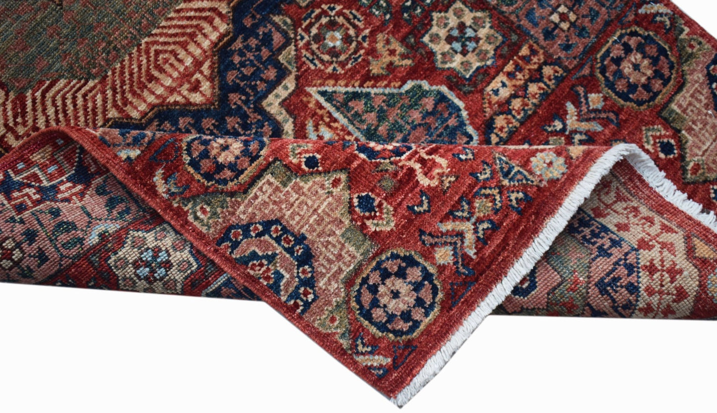 A handwoven Afghan Chobi runner featuring a traditional red Mamluk medallion pattern.