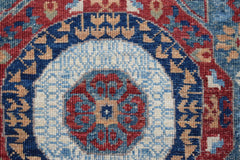 A close-up of a handwoven Afghan Chobi runner featuring a detailed blue and red Mamluk medallion.