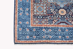 A handmade Afghan Chobi runner rug featuring a blue field with intricate geometric patterns.