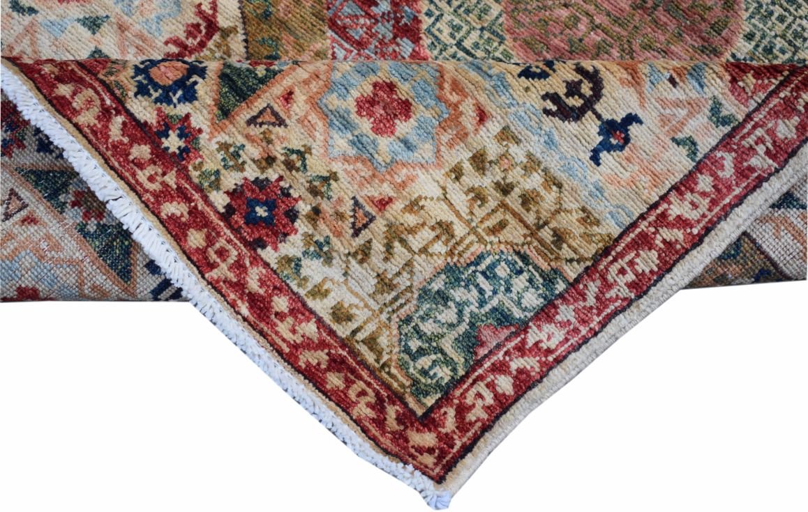 A folded Afghan Chobi runner rug featuring a traditional Mamluk medallion pattern in muted tones.