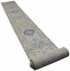 A long, handwoven Afghan Chobi runner rug featuring traditional geometric patterns in blue and gold.