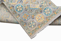 A handwoven Afghan Chobi runner featuring a geometric floral pattern in blue, yellow, and orange.