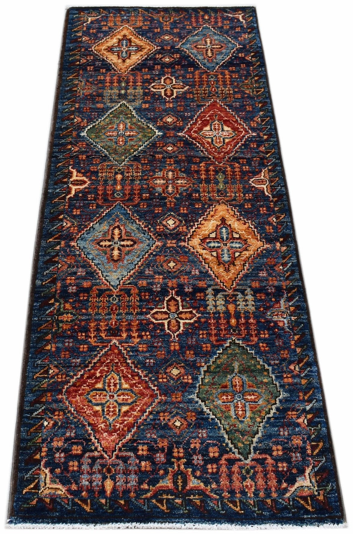 A handmade Afghan Chobi runner rug featuring a blue field with colorful geometric diamond motifs.