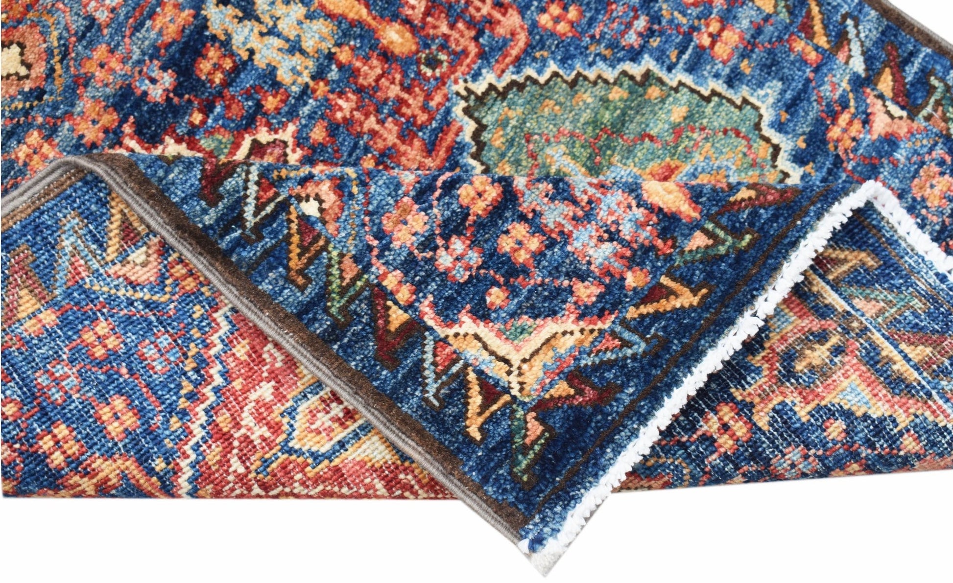 A folded Afghan Chobi runner featuring a traditional intricate pattern in blue, red, and gold.