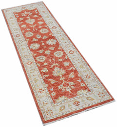A handmade Afghan Chobi runner rug featuring a traditional floral pattern in red and cream tones.