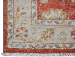 A close-up of an Afghan Chobi runner featuring a traditional floral pattern in red and beige tones.