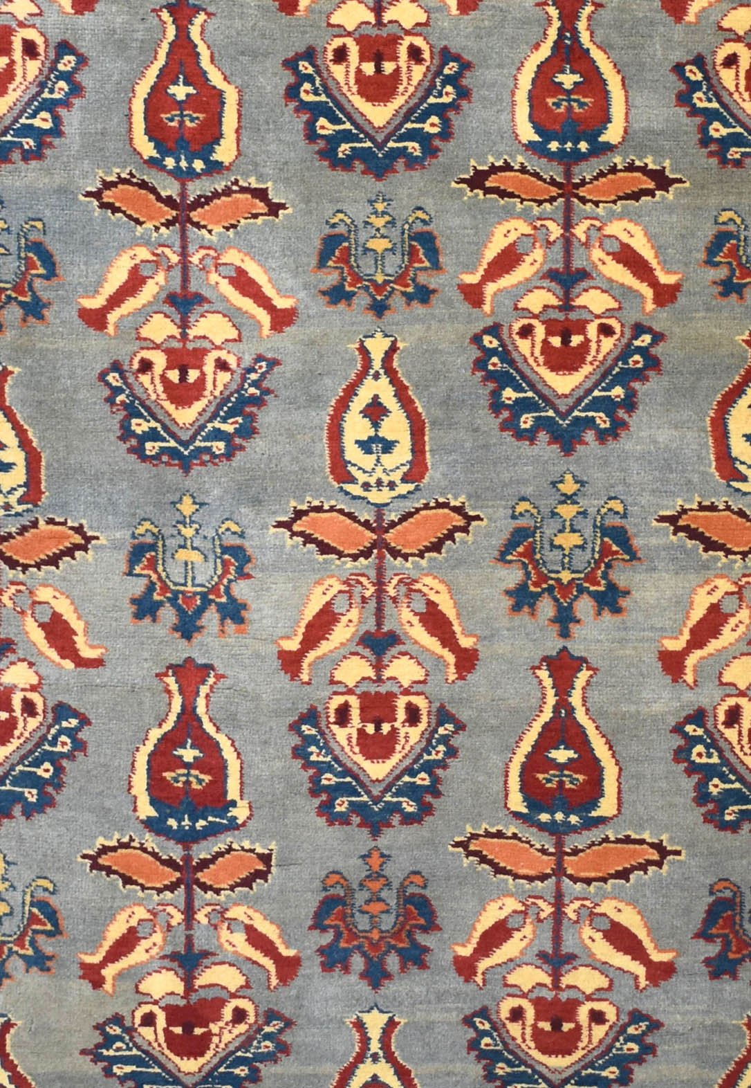 Handmade Afghan Chobi runner featuring a repeating floral motif in red, blue, and cream on grey.