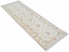 A handmade Afghan Chobi runner rug featuring a traditional floral pattern in soft, earthy tones.