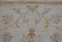 A close-up of an Afghan Chobi runner featuring a traditional floral pattern in soft earth tones.