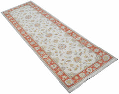 An Afghan Chobi runner rug featuring a floral pattern in muted tones with a burnt orange border.