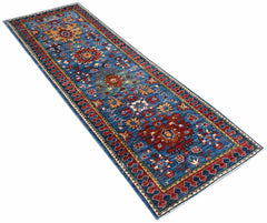 A handmade Afghan Chobi runner rug featuring traditional floral patterns in blue, red, and gold.