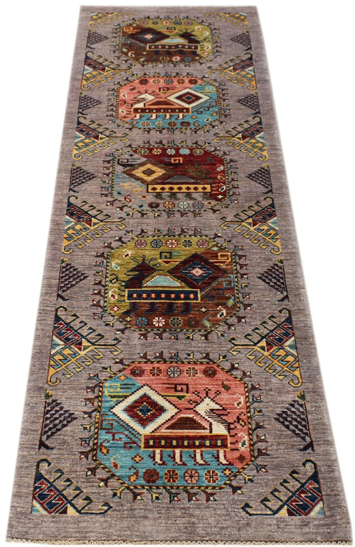 An Afghan Chobi runner rug featuring a grey field with repeating geometric medallions.