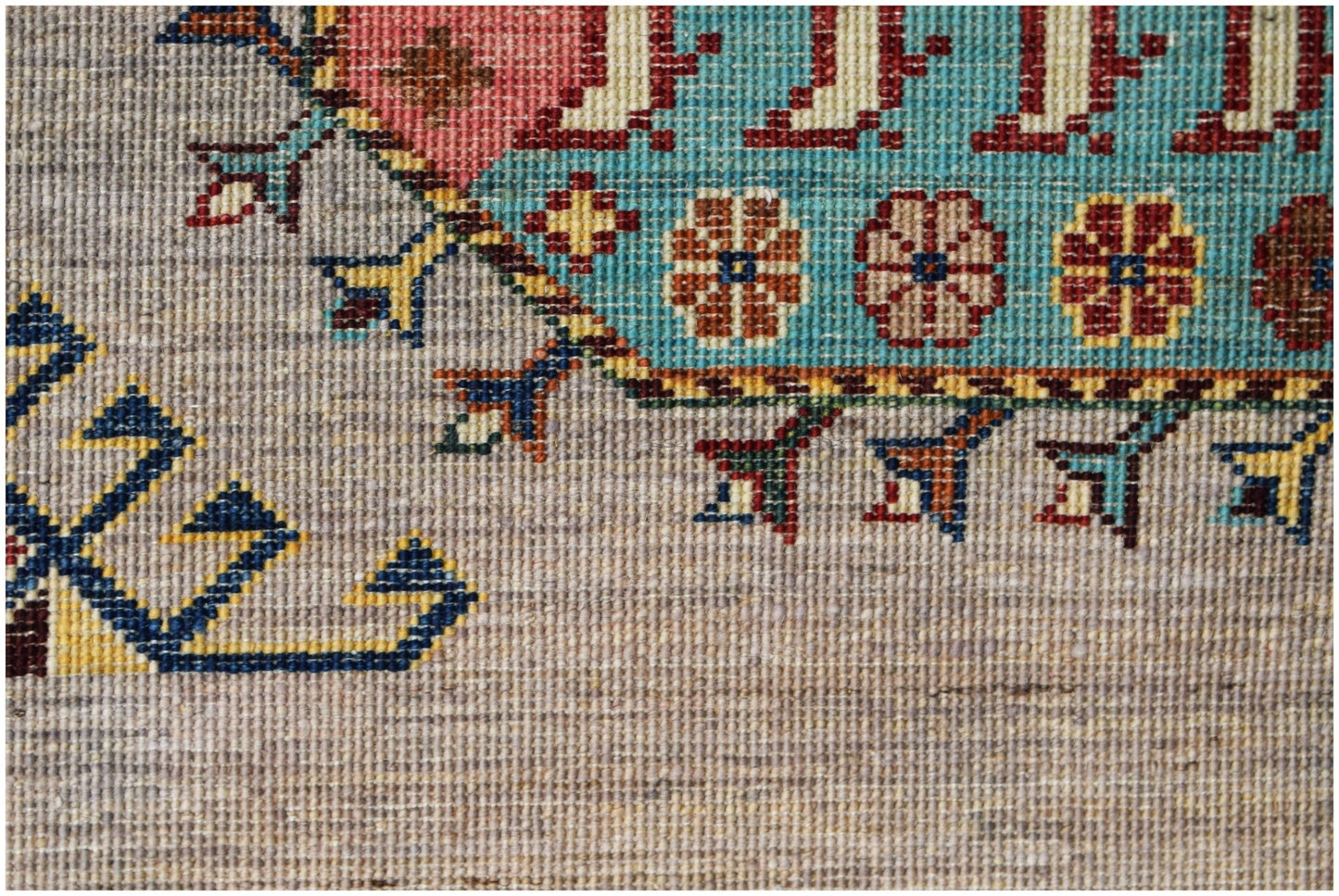 A close-up of a hand-knotted Afghan Chobi runner featuring intricate floral and geometric patterns.