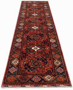 A handmade Afghan Chobi runner rug featuring traditional geometric patterns in red, blue, and cream.