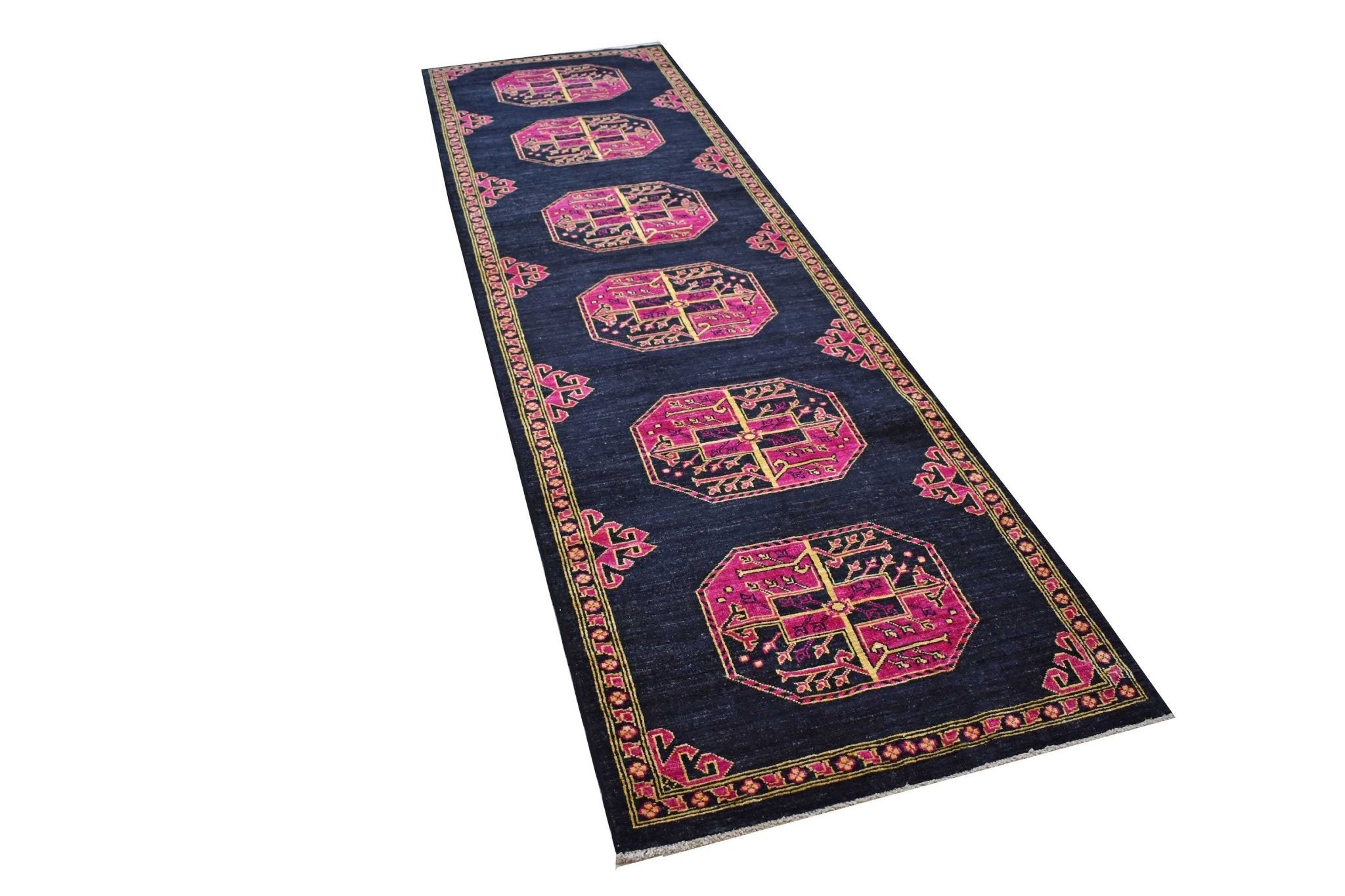 A handmade Afghan Chobi runner rug featuring magenta geometric medallions on a dark blue field.