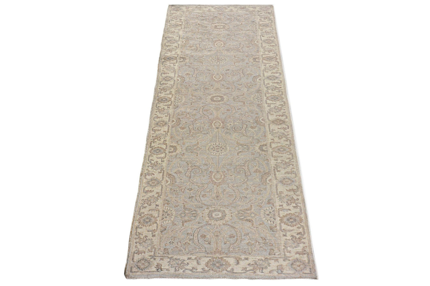 An Afghan Chobi runner rug featuring a traditional floral pattern in soft beige and blue tones.