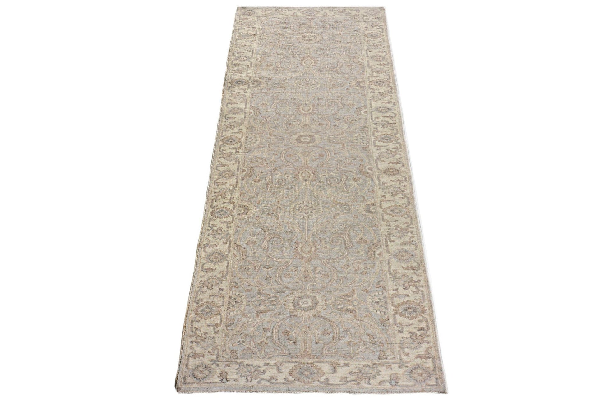 An Afghan Chobi runner rug featuring a traditional floral pattern in soft beige and blue tones.