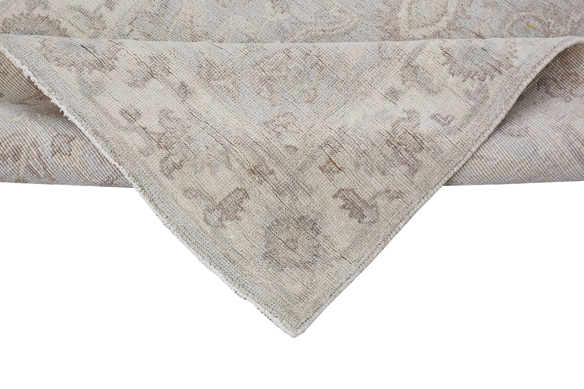 A corner of a handmade Afghan Chobi runner featuring a traditional beige and brown floral pattern.