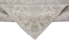 A corner of a handmade Afghan Chobi runner featuring a traditional beige and brown floral pattern.