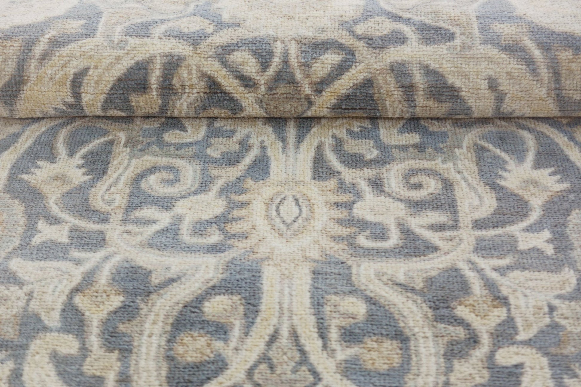 A handmade Afghan Chobi runner featuring a traditional floral pattern in grey and beige wool.