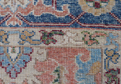 A close-up of a hand-knotted Afghan Chobi runner featuring intricate floral patterns in wool.