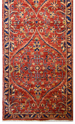 Handmade Afghan Chobi runner rug featuring a central diamond medallion on a red floral field.