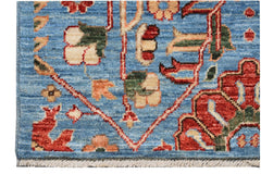 Handmade Afghan Chobi runner featuring traditional floral patterns in red and cream on a blue field.