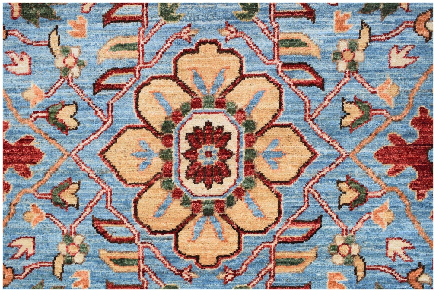 An Afghan Chobi runner featuring a traditional floral medallion pattern in tan, red, and blue.