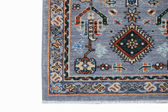 A handmade Afghan Chobi runner featuring a blue field with traditional geometric patterns.
