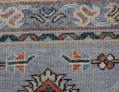 A close-up of a hand-knotted Afghan Chobi runner featuring intricate floral patterns in wool.