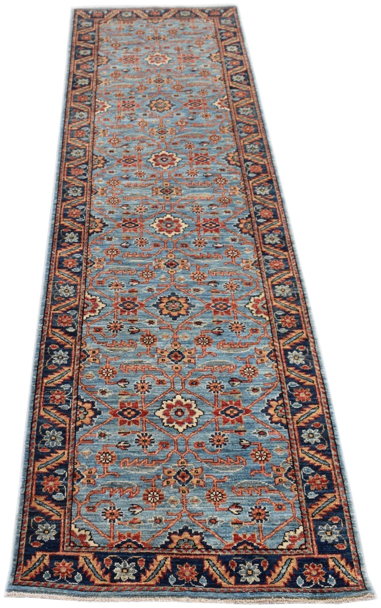 A handmade Afghan Chobi runner rug featuring a traditional floral pattern in blue and rust tones.